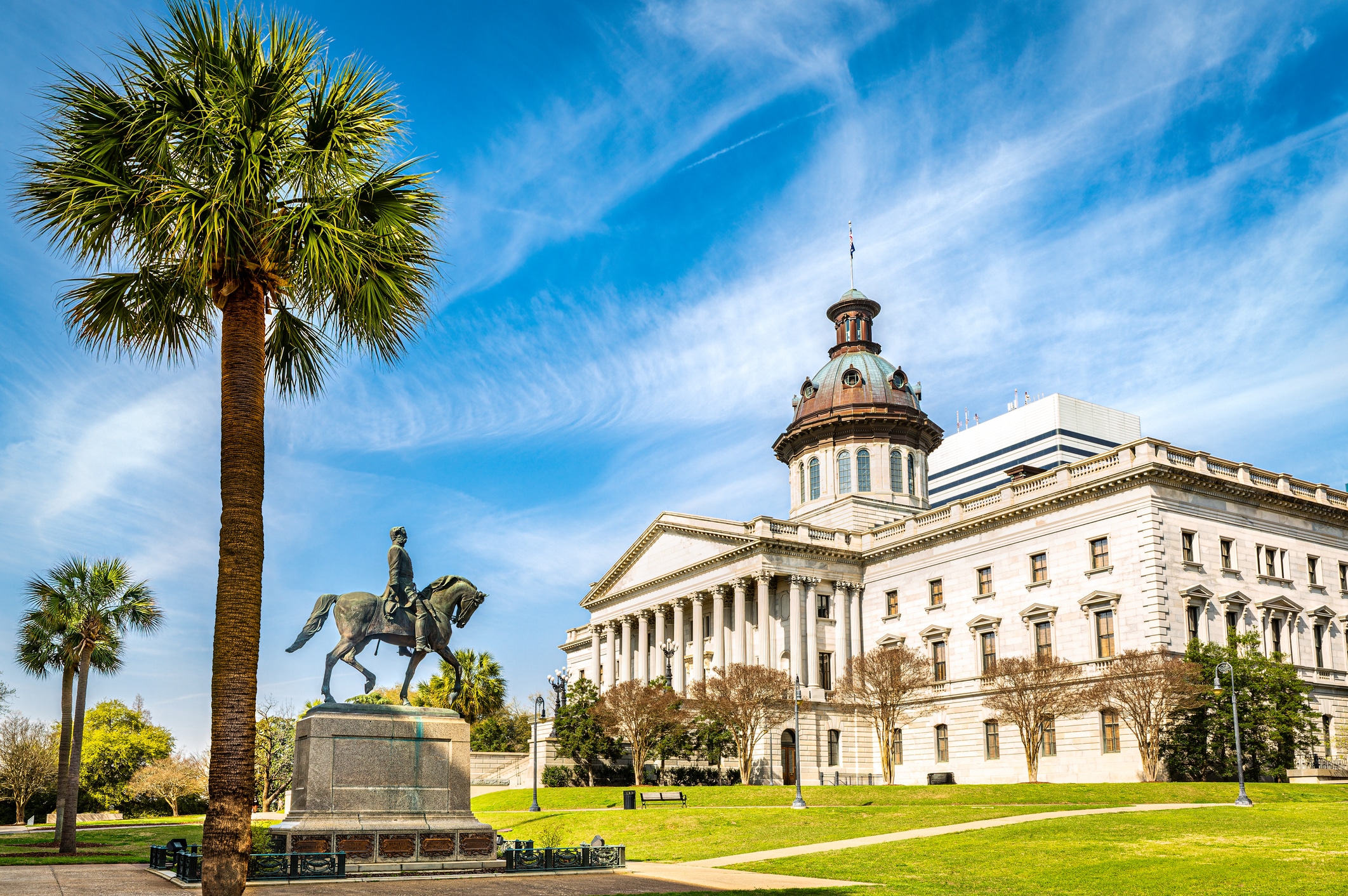 South Carolina State House, in Columbia, SC, and Wade Hampton III Statue on a sunny morning. The South Carolina State House is the building housing the government of the U.S. state of South Carolina